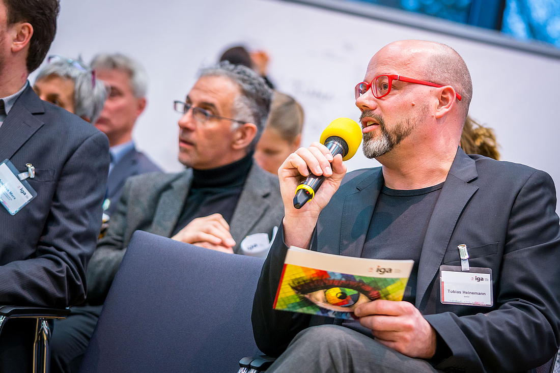 iga.Kolloquium 2017: Der Moderator Tobias Heinemann spricht ins Mikrophon