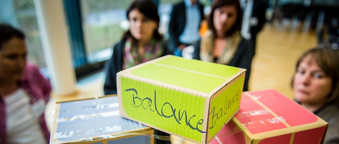 Ein Würfel mit der Aufschrift Balance liegt auf einem Stapel anderer Würfel.