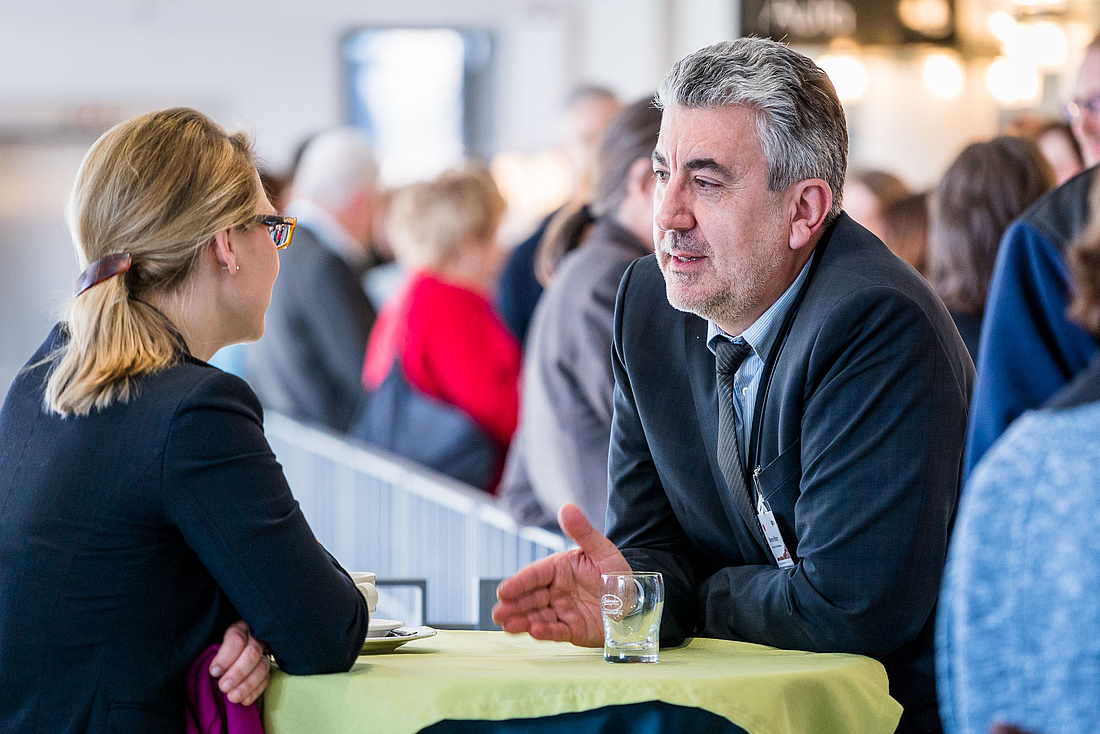 Ein Teilnehmer ist im Gespräch mit einer anderen Teilnehmerin.