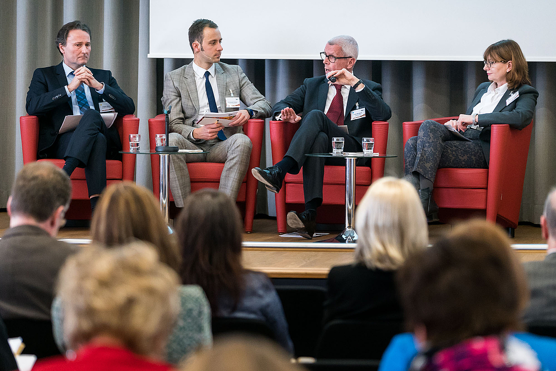 Ein Mann moderiert eine Gesprächsrunde im Plenum.