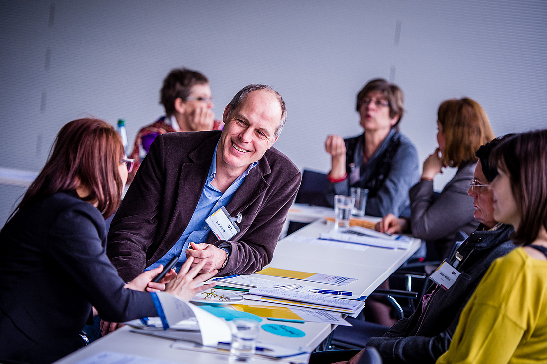 Eine Arbeitsgruppe sitzt an einem Tisch und diskutiert.