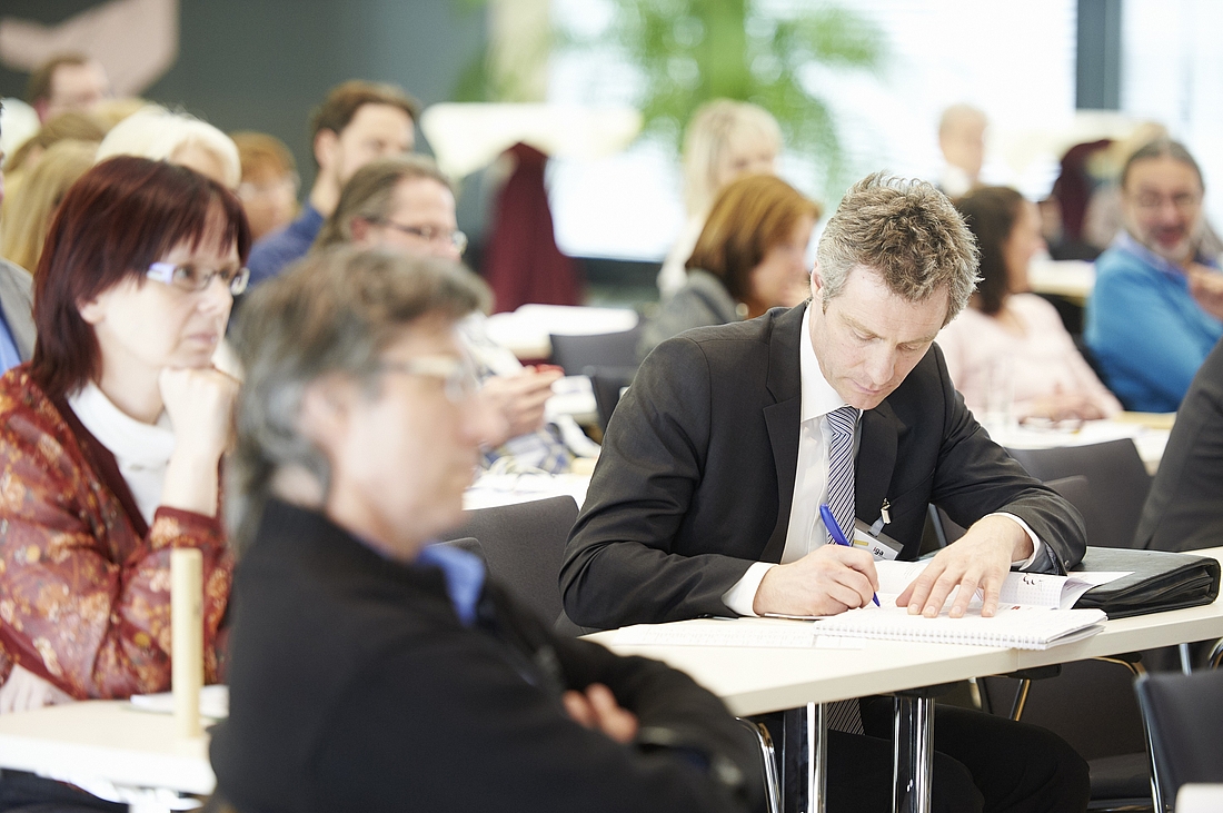 iga.Kolloquium 2015: Ein Besucher macht sich Notizen im Veranstaltungsaal 