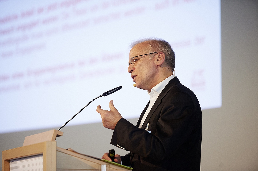 iga.Kolloquium 2015: Ein Referent auf der Bühne spricht ins Mikrofon 