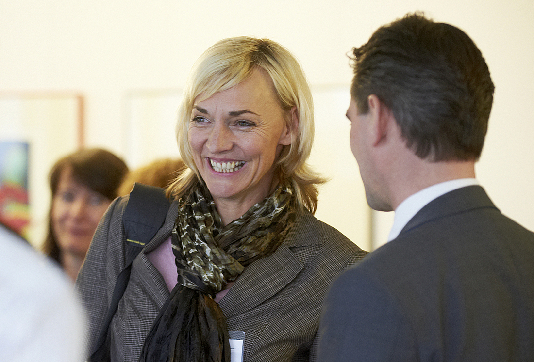 Eine Frau unterhält sich in der Pause mit anderen Teilnehmern.