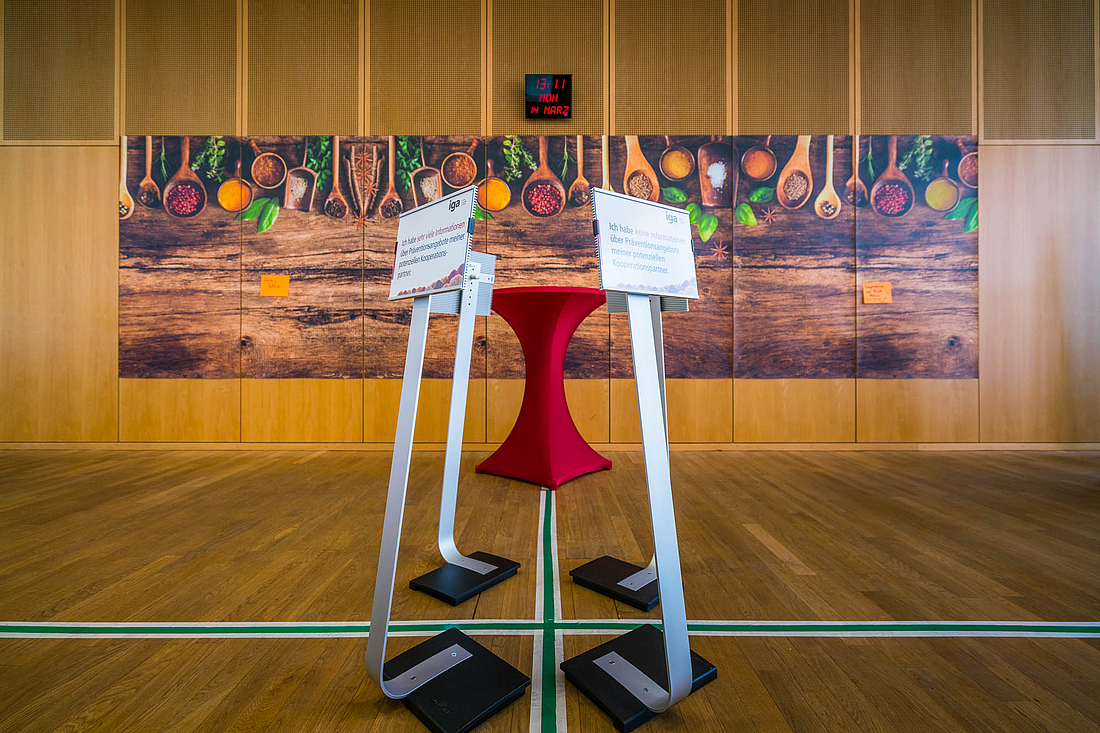 Ein Kreuz teilt den Boden in 4 Abschnitte. In jedem Abschnitt steht eine Tafel mit einer Aussage. 