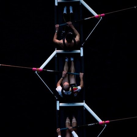 Mehrere Ruderer sitzen einem Sportruderboot.