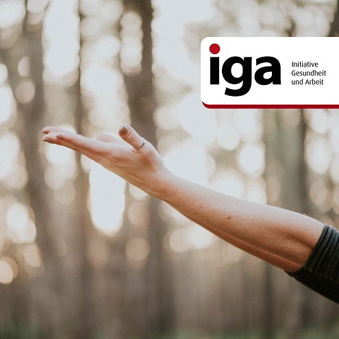 Ein Mensch im Wald streckt beide Arme in die Höhe.