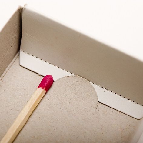 Ein letztes Streicholz liegt in einer Streicholzschachtel.